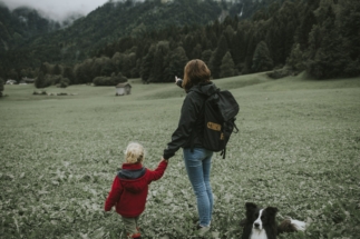 Österreich, Vorarlberg, Mellau, Mutter und Kleinkind mit Hund bei einem Ausflug in den Bregenzerwald