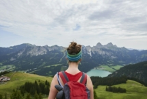 Rückansicht einer Wanderin mit Blick über das Tal in den Tannheimer Bergen, Tirol, Österreich