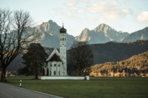 Blick auf die Kirche St. Coloman bei Schwangau an einem Herbstmorgen, Alpen im Hintergrund
