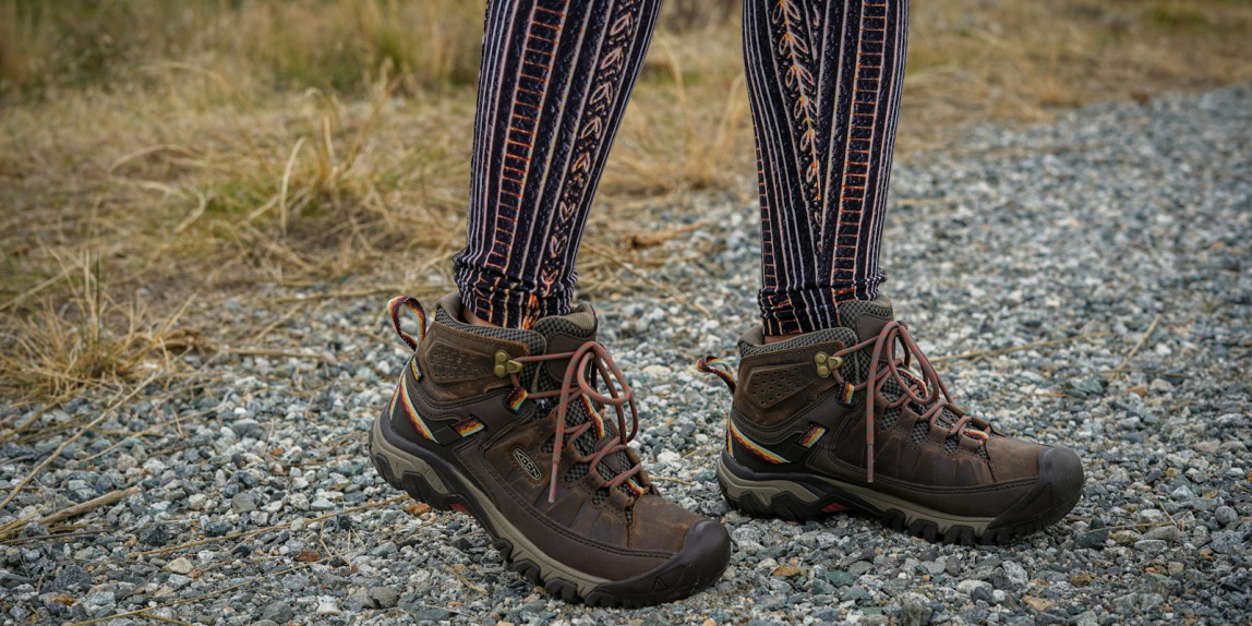 person wearing black leather hiking boots