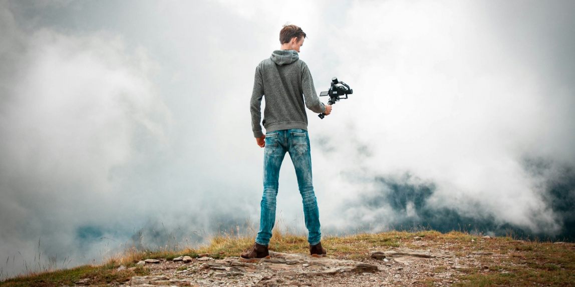 man holding camera with stabilizer while standing