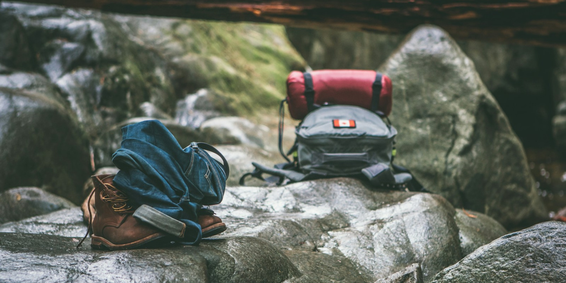 two gray and orange backpacks on gray rocks at daytime