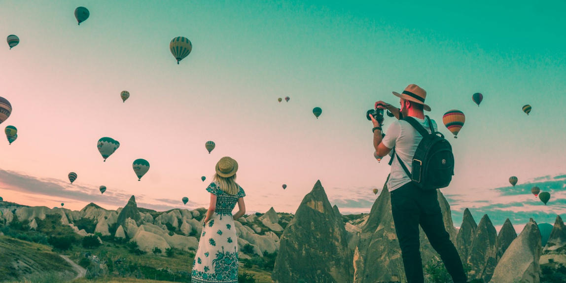 man taking photo of hot air balloons