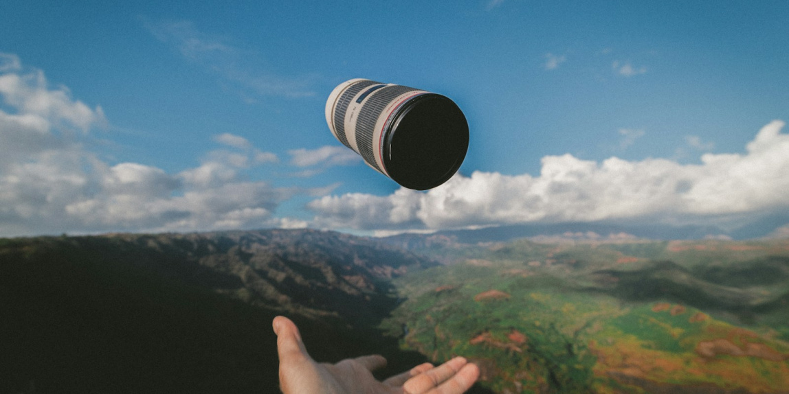 person throwing black and white Canon lens