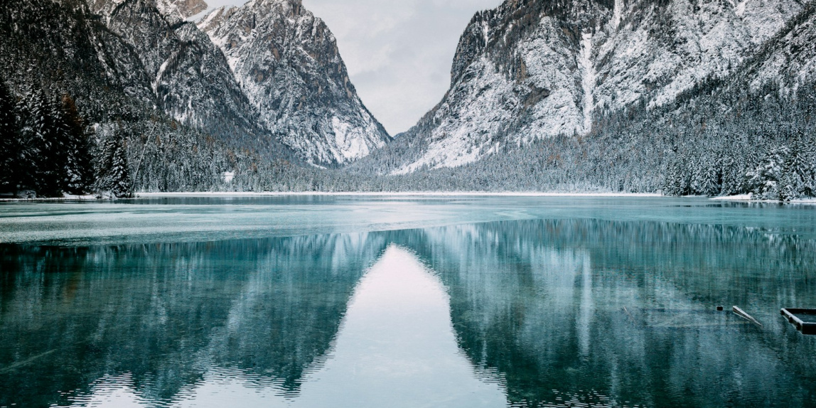 body of water and snow-covered mountains during daytime