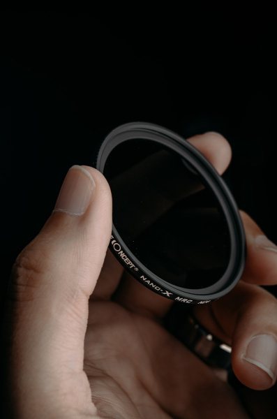a hand holding a camera lens