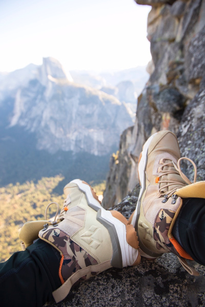 person sitting on rock near gray fault-block mountain