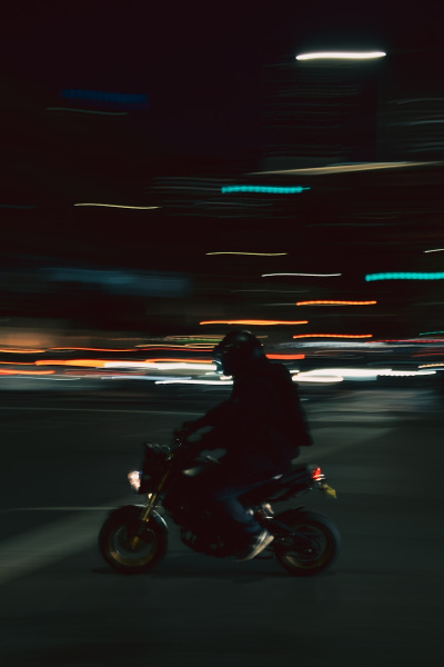 A man riding a motorcycle down a street at night