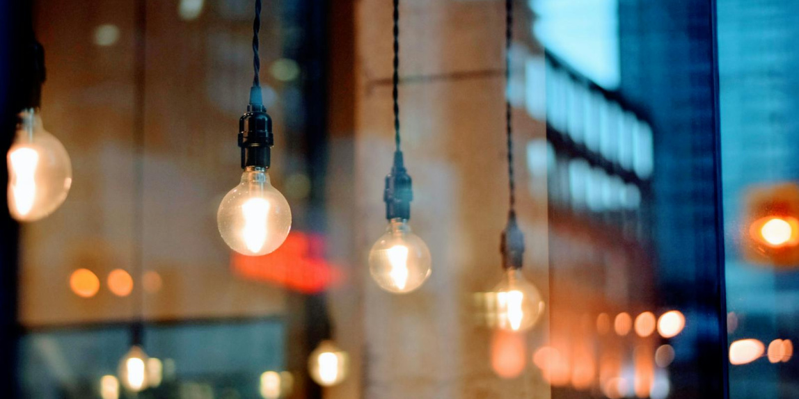 A creative shot of illuminated bulbs with city reflections, showcasing evening ambiance.