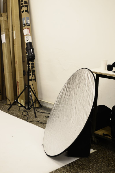 Photography studio setup featuring equipment and reflector for professional shoots.