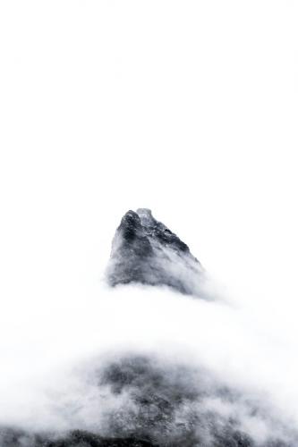 ein Schwarz-Weiß-Foto von einem Berg in den Wolken